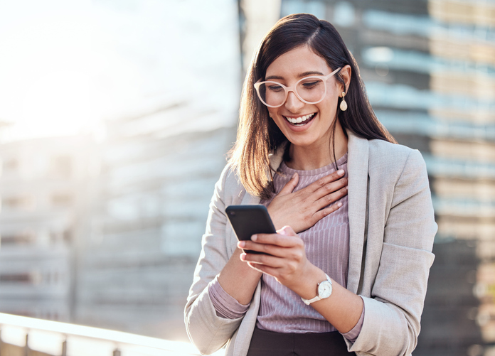 Smiling woman texting on her mobile