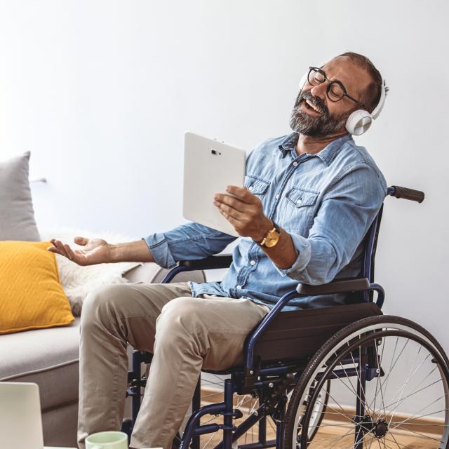 Man in wheelchair with headphones looking at ADA compliant images