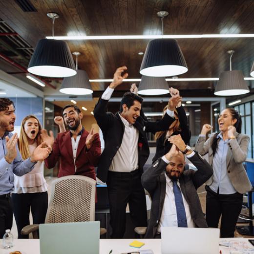 Office workers jumping for joy and cheering