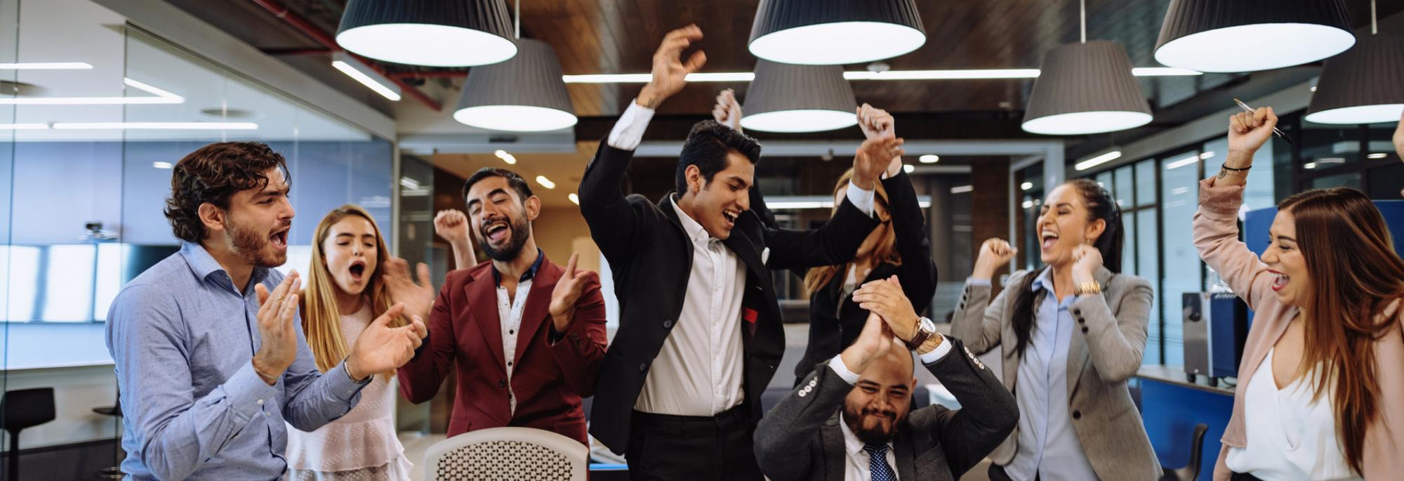 Office workers jumping for joy and cheering