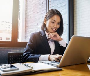 Businesswoman working at desk on laptop