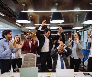 Office workers jumping for joy and cheering