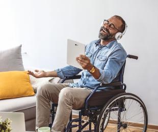 Man in wheelchair with headphones looking at ADA compliant images